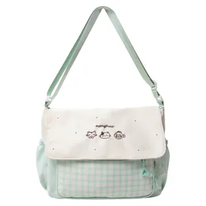 Detalle de la solapa del bolso bandolera a cuadros verde menta con bordado de gato.
