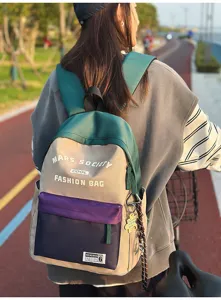 Detailansicht des farbblockierten Rucksacks mit mehreren Taschen und einem niedlichen Anhänger.