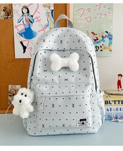 Niedlicher hellblauer Schulrucksack mit Pünktchen Schleife, Plüschknochen und Welpenanhänger.