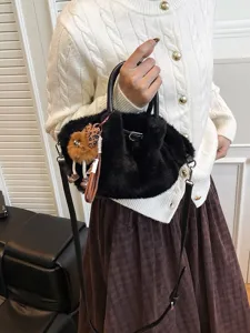Black plush bucket bag for women, soft furry shoulder crossbody bag with cute fluffy pendant.