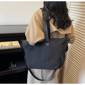 Detailed view of the black minimalist canvas tote bag in a stylish daily lifestyle scene.