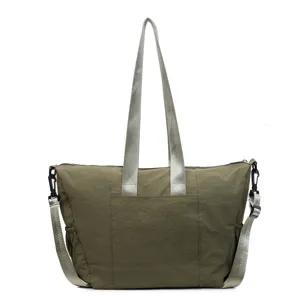 Close-up detail of the olive green nylon tote bag, showing sturdy straps and durable fabric.