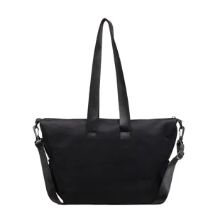 Black canvas tote bag detail view showcasing sturdy shoulder straps and metal hardware components.
