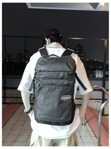 Vue détaillée du sac à dos à carreaux avec grande capacité, poches zippées et bretelles confortables.