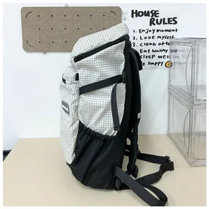 Sac à dos à carreaux décontracté vue latérale, cartable en toile durable avec grands compartiments.