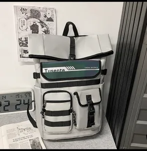 Sac à dos décontracté gris multi-poches avec bretelles tactiques et rabat vert stylé.