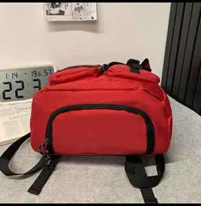 Vue détaillée du sac à dos rouge décontracté avec poche zippée et bretelles réglables.