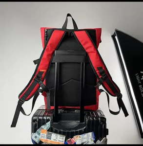 Grand sac à dos de voyage rouge et noir avec sangle de valise et bretelles ergonomiques pour homme.
