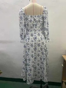 Back view of a white floral long sleeve maxi dress featuring a square neckline and backless design.