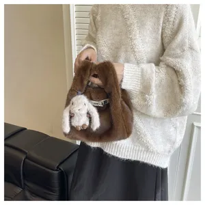Schicke braune Plüschhandtasche mit niedlichem Hasenanhänger und elegantem Metallverschluss.
