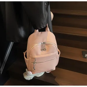 Close-up detail shot of the pink PU leather mini backpack showing texture, zippers and chain.