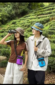 Dettaglio all'aperto che mostra eleganti borse a secchiello a tracolla unisex e colorate.