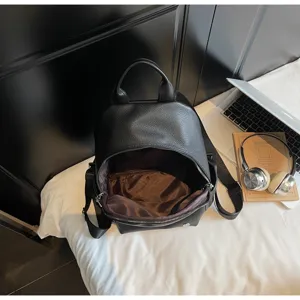 Black PU leather mini backpack detail, featuring zipper, handle and straps for daily use.