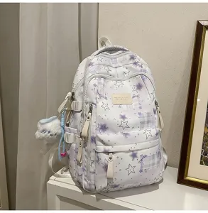 Vue de detail du sac a dos etudiant élégant de grande capacite avec motif d'etoiles et peluche.
