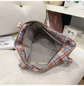 Vista detallada del bolso de hombro retro a cuadros para mujer con forro de rayas.