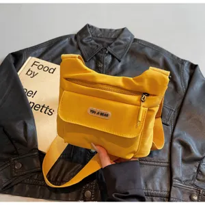 Detailansicht der gelben lässigen Umhängetasche mit mehreren Taschen und verstellbarem Gurt.