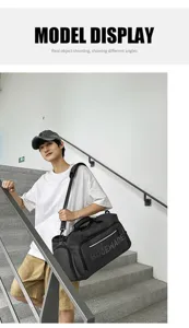 Detail view of large capacity black travel gym duffel bag showing model wearing it on stairs.