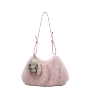 Detail view of the stylish pink plush underarm bag featuring a cute furry animal charm.