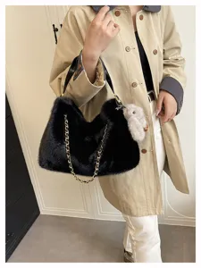 Detailaufnahme der schwarzen Damen Plüsch Umhängetasche mit goldener Kette und Häschen Anhänger.