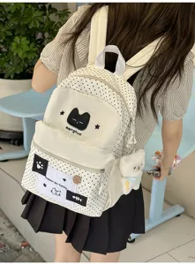 Vista detallada de la mochila de lunares con diseño de gato y bonito colgante de peluche suave.
