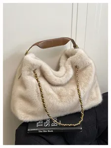 Detailaufnahme der stilvollen beigen Plüsch-Umhängetasche mit Kette und Ledergriff.