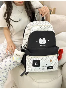 Vista detallada de la bonita mochila de lona de lunares en blanco y negro con estampado de gato.