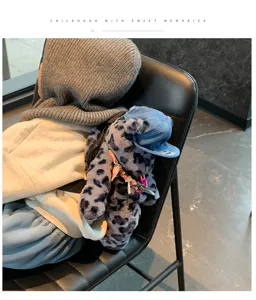 Detailaufnahme des kuscheligen Leopardenmuster-Bärenrucksacks mit süßer Kappe und Anhängern.
