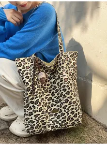 Detailansicht der stylischen Canvas-Tasche mit Leopardenmuster und charmantem Anhänger.