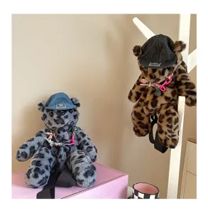 Detailansicht des niedlichen Leoparden-Plüschbären-Rucksacks mit Jeansmütze, trendige Plüschtasche.