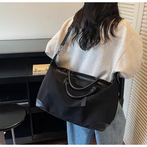 Borsa da viaggio nera con manici in pelle, capiente per brevi viaggi e uso quotidiano.