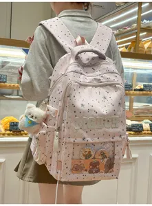 Vue détaillée du grand sac à dos d'école avec motif d'étoiles et joli pendentif.