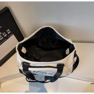 Dettaglio dall'alto di borsa da viaggio bianca con fodera nera e cinghie robuste.