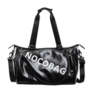 Dettaglio borsa sportiva lucida nera, borsa da viaggio impermeabile a tracolla fitness.
