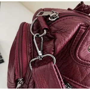 Λεπτομέρεια από μπορντό τσάντα χιαστί PU με ασημί μεταλλικά εξαρτήματα και φερμουάρ.