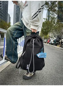 Vue détaillée d'un sac à dos noir avec cordon de serrage montrant une grande capacité.
