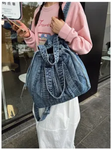 Vue détaillée du sac à dos en denim lavé rétro, élégant sac de voyage multifonction.