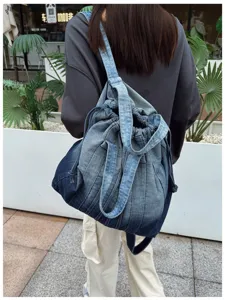 Vue détaillée du sac à dos en denim lavé vintage, avec une texture unique et un double usage.