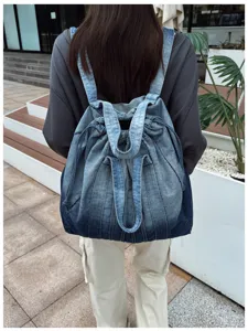 Détail de vue arrière du sac à dos en denim lavé style vintage, grande capacité pour l'école.