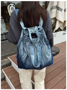 Vue détaillée d'un sac à dos en denim lavé rétro porté, sac d'école décontracté et pratique.