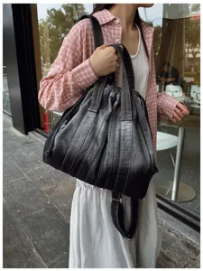 Vue détaillée du sac à dos en denim lavé vintage, montrant le tissu dégradé et les bretelles.
