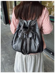 Vue détaillée du sac à dos en denim lavé vintage, style décontracté look lifestyle.