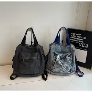 Washed denim backpack detail showing large capacity, dual shoulder straps and pocket.