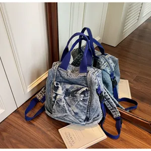 Detailed view of the washed denim backpack showcasing its large capacity and sturdy blue straps.