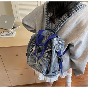 Detailed view of a trendy blue acid-washed denim backpack for women, spacious and stylish.