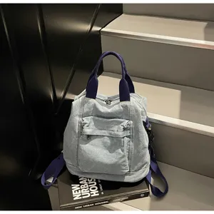 Detailed shot of casual denim backpack with blue straps, stylish daily accessory on stair