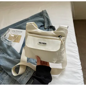 Freizeit cremeweisse Segeltuch Umhaengetasche mit vielen Taschen und breitem Gurt Detail view.