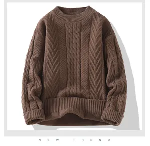 Dettaglio di maglione in maglia trecce marrone con tessuto strutturato e scollo rotondo comodo.