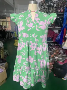 Detailed view of women floral print dress, V-neck and ruffle sleeves in factory scene.