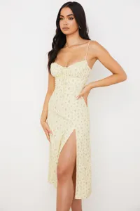 Detailed view of the yellow floral spaghetti strap midi dress with a sexy front slit design.