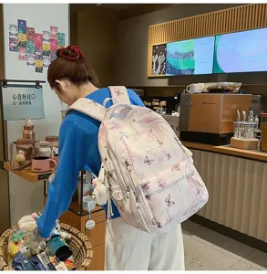 Stylischer Schülerrucksack mit Schmetterlingsdruck im gemütlichen Café-Detailblick.
